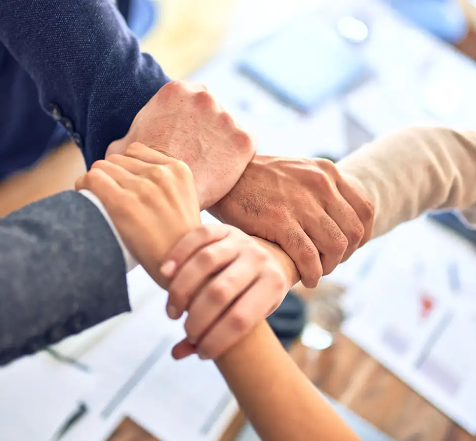 Four people holding eachother's wrists making a square