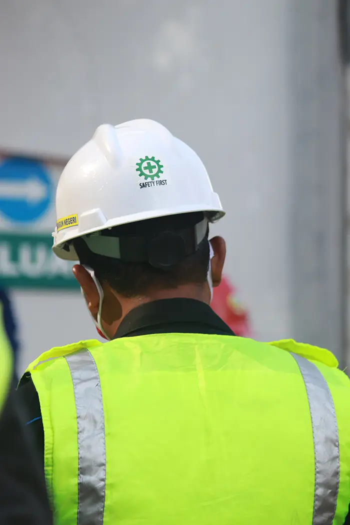 Back of person with hardhat and vest